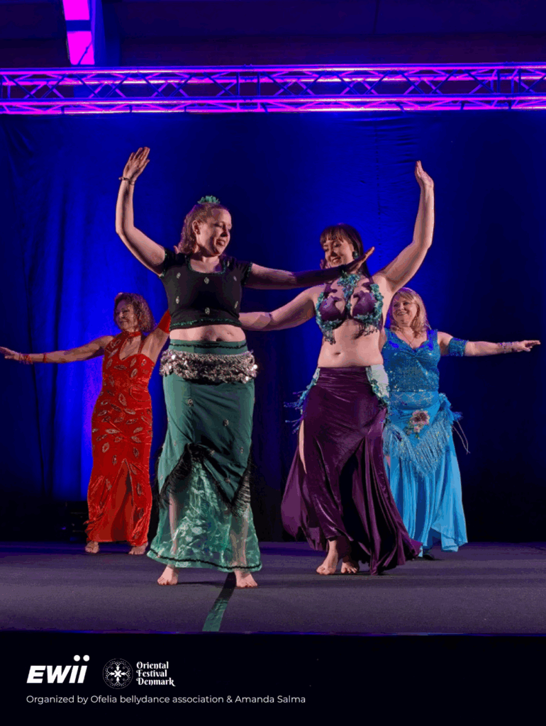 Amanda og tre elever fra optrædegruppen Nesrite optræder med en trommesolo med farverige kostumer under Oriental Festival Denmark i Kolding. Mørk baggrund fremhæver bevægelser og farver.